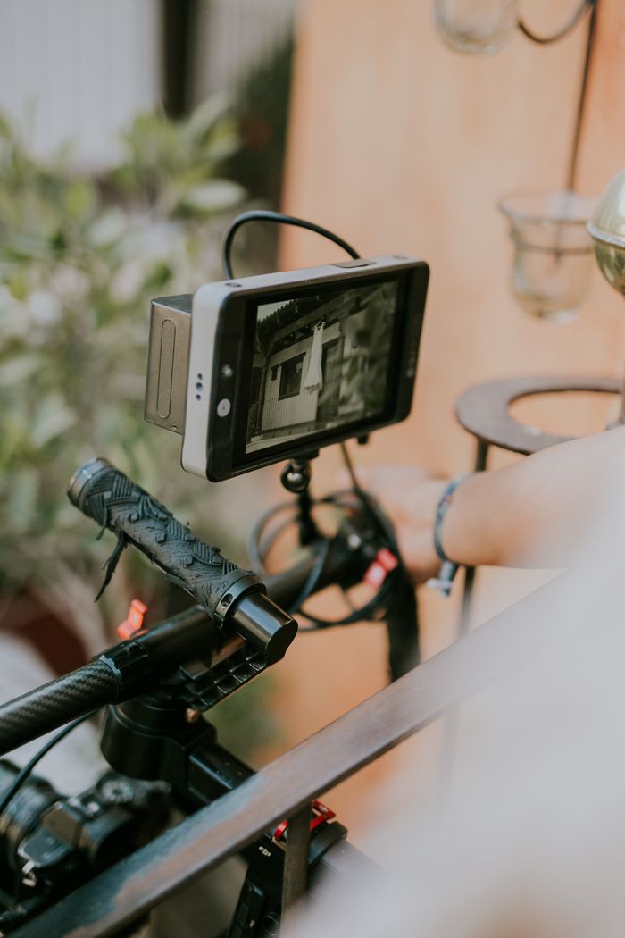Home A detailed view of a camera rig with a mounted digital display screen outdoors.