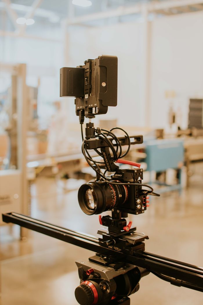 Home Close-up of a professional camera rig setup on a tripod in a modern studio setting.
